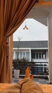 a person laying on a bed looking out of a window at Chu homestay in Thôn Trường Giang +22 photos