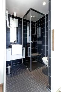 a bathroom with a shower and a sink and a toilet at Hotel Wirtshaus Garbe in Stuttgart