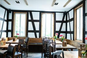 a restaurant with wooden tables and chairs and windows at Hotel Wirtshaus Garbe in Stuttgart +21 photos