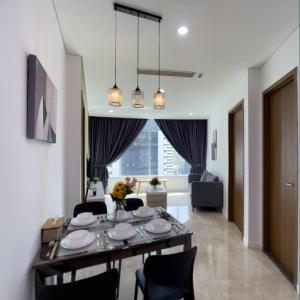 a dining room table with chairs and a living room at Vortex Apartment klcc by HouseFull in Kuala Lumpur
