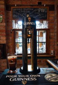 a coffee machine sitting on a table with a glass of beer at Liptov Lodge in Liptovský Mikuláš