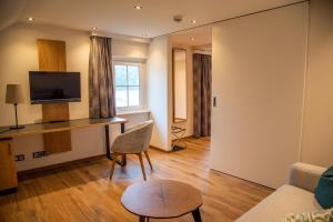 a living room with a desk and a chair at Seehotel Schlick in Fuschl am See