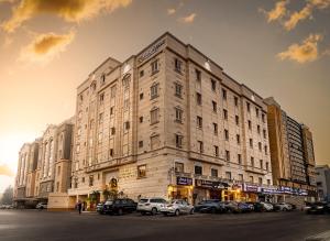a large building with cars parked in a parking lot at Rasis Serviced Apartments in Jeddah