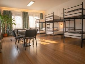 a room with bunk beds and a table and chairs at Noclegi PODZAMCZE PTTK in Przemyśl