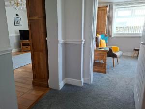 a hallway with a living room with a chair and a window at Thurlestone House in St Ives