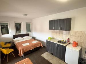 a bedroom with a bed and a kitchen with a sink at Hotel Avanti in Zenica