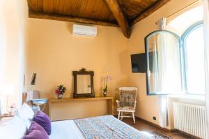 a bedroom with a bed and a mirror and a chair at CollinaBlu in Torre San Severo