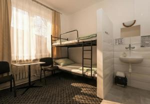 a room with two bunk beds and a sink at Noclegi PODZAMCZE PTTK in Przemyśl