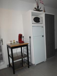 una mesa pequeña con microondas encima de una nevera en Appartement Le Romarin, en Mallemort 24 fotos más