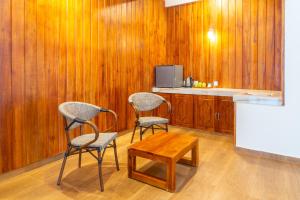 two chairs and a table in a kitchen with wooden walls at Mount Hunt Resort Beragala Haputale in Beragala