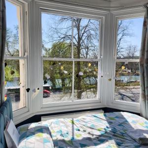 a bedroom with two windows and a bed in front of it at Great Central self-contained flat in Cambridge
