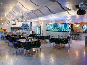 a restaurant with tables and chairs and a large aquarium at Silva Villa in Bedfordview