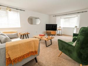 a living room with a couch and a tv at Long Barn in Bridport