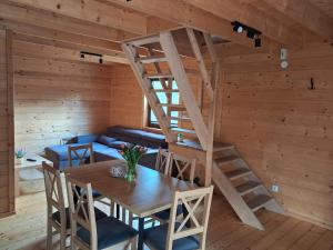 a wooden room with a wooden table and a spiral staircase at Domki Dębowe Wzgórze in Potok Złoty