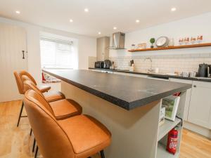 a kitchen with a counter and some chairs in it at Long Barn in Bridport