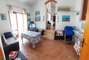 a living room with a table and a television at Macari Villa Laura in Macari