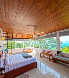 a bedroom with a large wooden ceiling and windows at Mount Hunt Resort Beragala Haputale in Beragala +63 photos