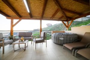 a porch with chairs and tables and a view of a hill at Kuća za odmor Aria in Krapina