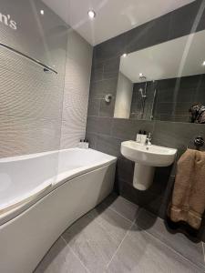 a bathroom with a bath tub and a sink at Heron's Hideaway in Wells next the Sea