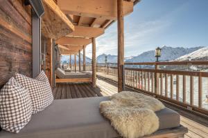 a porch with a couch on a wooden deck at Hotel Alpenfriede in Sölden