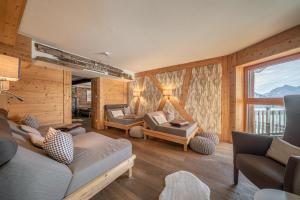 a living room with couches and chairs and a window at Hotel Alpenfriede in Sölden