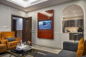 a living room with a couch and a tv on a wall at Rasis Serviced Apartments in Jeddah
