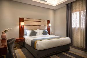 a bedroom with a large bed and a window at Rasis Serviced Apartments in Jeddah