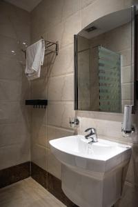 a bathroom with a white sink and a mirror at Rasis Serviced Apartments in Jeddah +78 photos