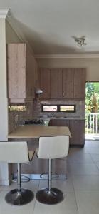 a kitchen with wooden cabinets and a counter with stools at Villa Ti Amo Flat in Ramsgate