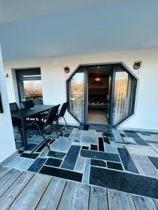 a dining room with a table and chairs on a tiled floor at Hobbitul lui Maș in Valea lui Maş