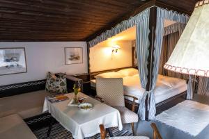 a hotel room with a bed and a table and a bedroom at Berghotel Blaickner's Sonnalm in Zell am See