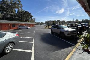 a parking lot with two cars parked in it at Stevens Motel by Capital O Ocala US 27 in Ocala