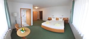 a hotel room with a bed and a table and a room at Pension Seeluft in Ahrenshoop