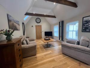 a living room with two couches and a tv at Heron's Hideaway in Wells next the Sea