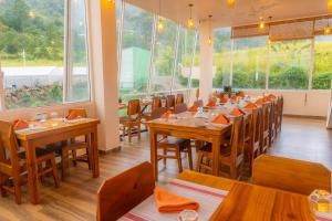 a restaurant with wooden tables and chairs and windows at Mount Hunt Resort Beragala Haputale in Beragala