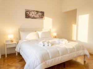 a bedroom with a white bed with towels on it at LARI - appartamento moderno in centro in Bari