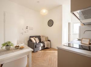 a kitchen and living room with a couch in the background at LARI - appartamento moderno in centro in Bari