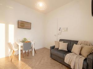 a living room with a couch and a table at LARI - appartamento moderno in centro in Bari +12 photos