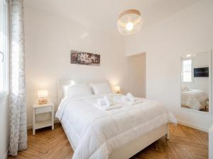 a white bedroom with a large white bed and a window at LARI - appartamento moderno in centro in Bari