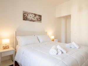 a bedroom with a white bed with towels on it at LARI - appartamento moderno in centro in Bari