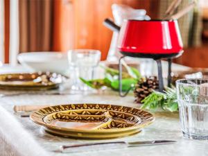 a table topped with gold plates and a red lamp at Chalet Sven Heul by Interhome in Nendaz +34 photos
