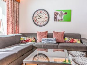 a living room with a couch and a clock on the wall at Apartment Rosablanche D31 by Interhome in Siviez