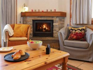 a living room with a table and a fireplace at Chalet Lara by Interhome in Nendaz
