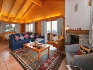 a living room with blue couches and a fireplace at Chalet Lara by Interhome in Nendaz