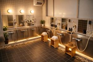a bathroom with three urinals and three toilets at 心斎橋難波関空直通 Ambers Hostel in Osaka