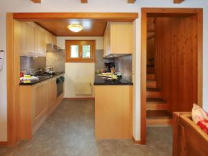 a kitchen with white cabinets and a stairway at Chalet Coucordin by Interhome in Nendaz +35 photos