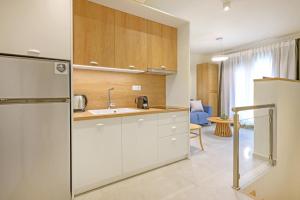 a kitchen with white cabinets and a refrigerator at Leon Apartments in Ierissos +56 photos