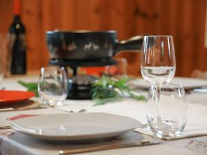 a table with two wine glasses and a plate on it at Chalet Coucordin by Interhome in Nendaz