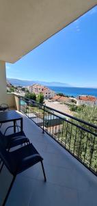 a balcony with a bench and a view of the ocean at Smit apartman in Novi Vinodolski