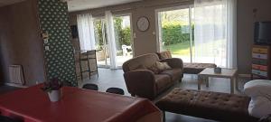 a living room with a couch and a table at Gîte spacieux, Proche Plage, Grand jardin in Neufchâtel-Hardelot